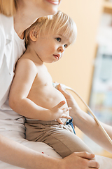 Image showing Small child being checked for heart murmur by heart ultrasound exam by cardiologist as part of regular medical checkout at pediatrician.