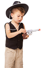 Image showing Kid, cowboy hat and revolver gun in studio isolated on a white background mockup space. Child, toy pistol and play in western costume for halloween, shooting or young boy dress up on holiday for fun