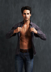 Image showing Handsome, fashion and portrait of man by a wall with trendy, cool and stylish outfit with confidence. Abs, attractive and young male model from Canada with casual shirt and jeans by gray background.