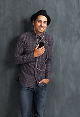 Image showing Happy, music and portrait of man on gray background with trendy style, clothes and casual outfit. Fashion, handsome and face of person with cellphone for listening to audio, radio and song playlist
