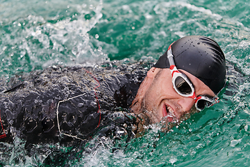 Image showing A professional triathlete trains with unwavering dedication for an upcoming competition at a lake, emanating a sense of athleticism and profound commitment to excellence.