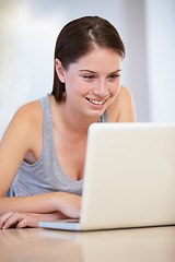 Image showing Home, laptop and woman or student in e learning, online education and typing for university or college research. Young person at a table or desk and reading on computer for website results or news