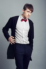 Image showing Portrait, fashion and man with business, professional and confident guy on a grey studio background. Person, corporate and model with suit, elegant outfit and stylish clothes with bow tie and worker
