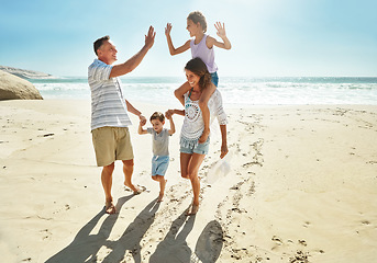 Image showing Parents, children and beach for high five in summer for travel vacation, ocean sunshine or sibling development. Man, woman and kids on sand for holiday relax walking or outdoor, clean air or smile