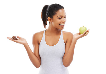 Image showing Man, apple and chocolate for healthy food choice or thinking of diet on a white background. African person with sweets versus green fruit in palm for detox decision or lose weight challenge in studio