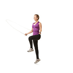 Image showing Fitness, skipping rope and woman on a white background for exercise, cardio workout and training. Sports, endurance and isolated person with gym equipment for health, wellness and jumping in studio