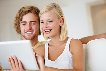 Image showing Happy, tablet and young couple on sofa browsing on social media or internet at apartment. Smile, digital technology and man and woman from Australia relax and scroll on website in living room at home