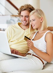 Image showing Happy couple, credit card and computer on sofa for online shopping, loan and digital money at home. Young woman and man on laptop for internet banking, easy website payment or e commerce registration