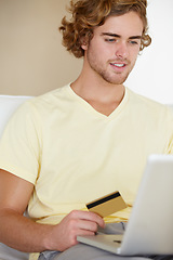 Image showing Young man, credit card and laptop for online shopping, fintech payment and digital money in trading or stock market. Online user, trader or person on his computer for internet banking or cash on sofa