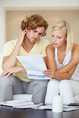 Image showing Couple, stress for bills and reading documents on sofa with debt, financial planning or budget risk and worry at home. Confused man and woman with house loan invoice, bankruptcy or mortgage paperwork