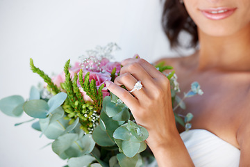 Image showing Diamond, wedding ring and hands of bride with bouquet, flowers and pride for commitment, celebration or marriage. Bridal, aesthetic and woman closeup with engagement jewelry or floral arrangement