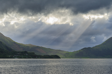 Image showing Majestic Rays of Sunlight Piercing Through Clouds Over a Tranqui