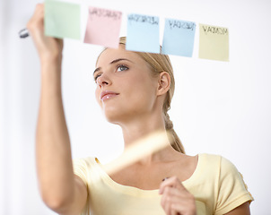 Image showing Business woman, writing and schedule planning on sticky notes or glass board for project or time management. Creative planner or worker with priority list, calendar or brainstorming of workflow ideas