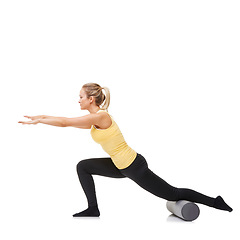 Image showing Woman, foam roller and stretching body in studio with lunge exercise, fitness and yoga workout on white background. Pilates, profile and agile lady balance on tube for training, strong core and power