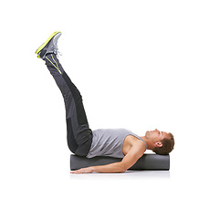 Image showing Exercise, foam roller and man in pilates back workout, legs stretching or wellness for rehabilitation strength. Floor, mockup space and studio athlete fitness, balance or training on white background