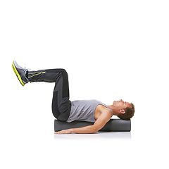 Image showing Workout, foam roller and man in pilates back exercise, legs stretching or stability for sports rehabilitation, wellness or recovery. Floor, mockup space and studio athlete balance on white background