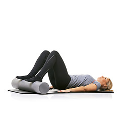 Image showing Pilates, foam roller and woman in core workout, exercise or wellness for sports rehabilitation on floor. Ground, mockup space and studio athlete fitness, training and lying on mat on white background