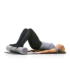 Image showing Core workout, foam roller and studio woman with bridge exercise, activity or wellness for sports performance on floor. Ground, mockup space and girl fitness, training and yoga mat on white background