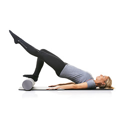 Image showing Legs workout, foam roller and studio woman with bridge exercise, pilates balance or gym performance challenge. Ground, body training and athlete core muscle, strength or fitness on white background