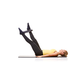 Image showing Woman, pilates ring and legs for stretching on yoga mat or resistance training, strong thighs or studio white background. Female person, equipment for muscle flexibility or exercise, health or mockup