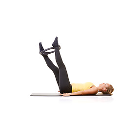Image showing Woman, pilates ring and legs for wellness workout on yoga mat or resistance training, strength or studio white background. Female person, equipment for muscle flexibility or balance, health or mockup