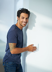 Image showing Man, wall and light switch in home bedroom or portrait smile for weekend, calm peace of holiday vacation. Male person, face and press for power electricity in residential apartment, flick or control
