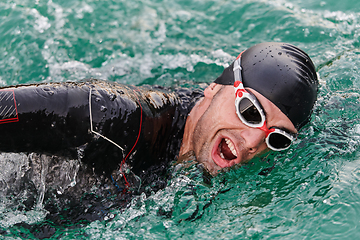 Image showing A professional triathlete trains with unwavering dedication for an upcoming competition at a lake, emanating a sense of athleticism and profound commitment to excellence.