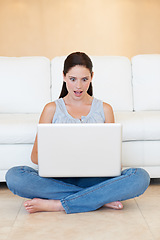 Image showing Surprise, woman and sitting with laptop on floor for good news or social media in living room at home. Shocked female person or freelancer on computer for notification, deal or alert by sofa at house