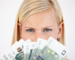 Image showing Eyes, finance and woman serious about money in studio on a white background for tax, salary or increase. Accounting, economy or payment and a young person with cash for bank savings or growth