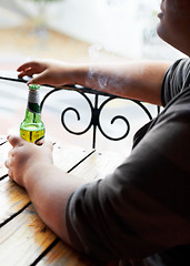 Image showing Outdoor, smoking and man with a beer, relax and weekend break at a restaurant, alcohol and pub. Person, outside and guy with cigarette, tobacco and drink with habit, bottle and peaceful with smoker