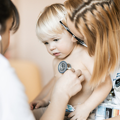 Image showing Doctor holding stethoscope and listening to child's heartbeat. Regular checkout at pediatrician at clinic or hospital. Healthcare and medical concept.