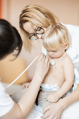 Image showing Small child being checked for heart murmur by heart ultrasound exam by cardiologist as part of regular medical checkout at pediatrician.