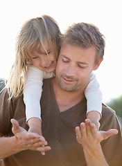 Image showing Happy, piggyback and father with kid in nature playing, having fun and bonding together. Smile, love and young dad carrying girl child from Canada holding hands for playful freedom with sky in a park