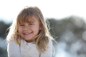 Image showing Nature, smile and portrait of girl child with positive, good and confident attitude in an outdoor park. Happy, cute and young kid from Canada with sweet personality in a field, garden or backyard.