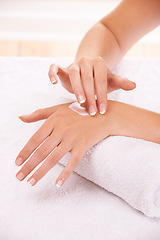 Image showing Skin, apply cream and hands in spa, closeup and massage on towel for care. Touch fingers, nails and woman on lotion treatment, natural cosmetics or dermatology moisturizer, beauty health or manicure