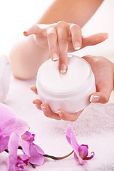 Image showing Woman, hands and flowers with cream for skincare, cosmetics or beauty products in salon or spa treatment. Closeup of female person with jar or container of lotion, SPF or creme for skin moisturizer