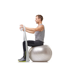 Image showing Yoga ball, resistance band and man doing workout in studio for health, wellness and bodycare. Sport, fitness and young male person from Australia with arms exercise or training by white background.