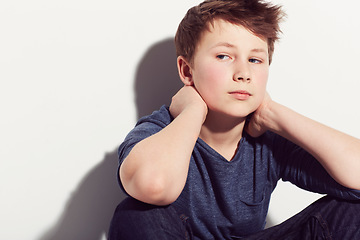 Image showing Serious, teenager and boy thinking in studio sitting in white background with anxiety. Student, worry and kid with mental health, stress from school or pose in trendy outfit with clothes on backdrop