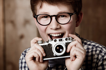 Image showing Mockup, portrait and boy with vintage camera with happiness and edgy fashion in glasses by backdrop. Child, face and nerd with retro photography equipment and eyewear for creative kids with vision