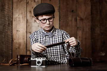 Image showing Photography, child and vintage with camera film, thinking and mockup in glasses by backdrop. Boy, idea and nerd with retro negative photos for pictures and eyewear for creative kids with inspection