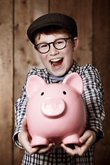Image showing Young boy, piggy bank and happy in portrait for excited, money saving and cash savings in youth with retro fashion. Child, smile and face for coin banking and safe for bills with glasses by backdrop