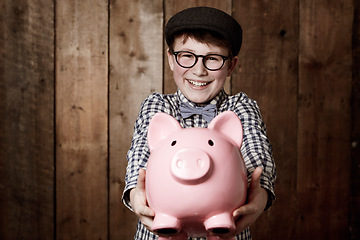 Image showing Child, piggy bank or excited in portrait by studio background, savings or finance lesson in youth. Boy, smile and face in coin banking of small change and cash learning in vintage fashion in mockup