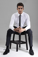 Image showing Shirt, tie and portrait of businessman with chair in studio, grey background and mock up space. Confident, man and entrepreneur sitting on stool with commitment, pride and attention in backdrop