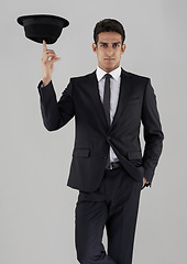 Image showing Man, suit and hat in studio portrait with confidence, spin or corporate fashion by white background. Person, model and edgy clothes with balance, pride and black fabric in shirt, tie and professional