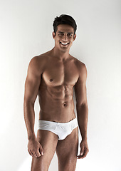 Image showing Portrait, muscle and man with underwear, smile and confident guy isolated on a white studio background. Person, mockup space and model with body, healthy and wellness with fitness, beauty and natural