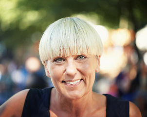 Image showing Portrait of mature woman in park with smile, nature and relax in forest for outdoor event. Happiness, celebration with adventure party and freedom, face of person with sunshine and bokeh on vacation.