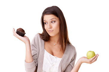 Image showing Doubt, decision and apple or muffin with a woman in studio isolated on a white background for food choice. Unsure, diet or nutrition with a confused young person holding fruit and dessert options