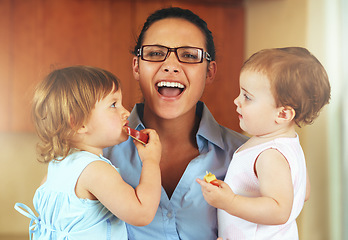 Image showing Portrait, happy woman and stress with children in home with snack, fruit or apple slice for eating. Female person, remote work and multitask for productivity, job and childcare with kids in a house