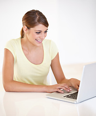 Image showing Woman, remote work or smile with laptop in studio to update blog post, social media or digital download on white background. Happy freelancer typing on computer for email, research or mockup at table