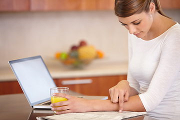 Image showing Woman, reading newspaper and kitchen with laptop, drinking orange juice and remote work at home. Computer, print media or freelancer check newsletter report for research, article information or story